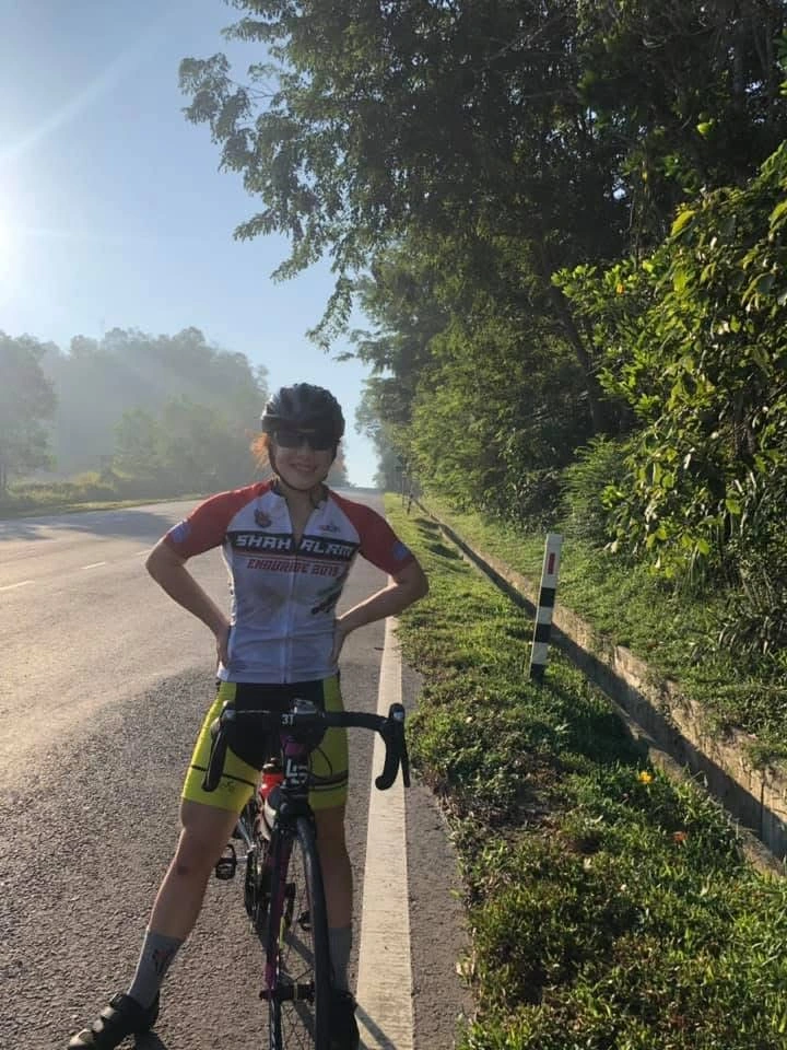 Cyclist standing beside a road bike