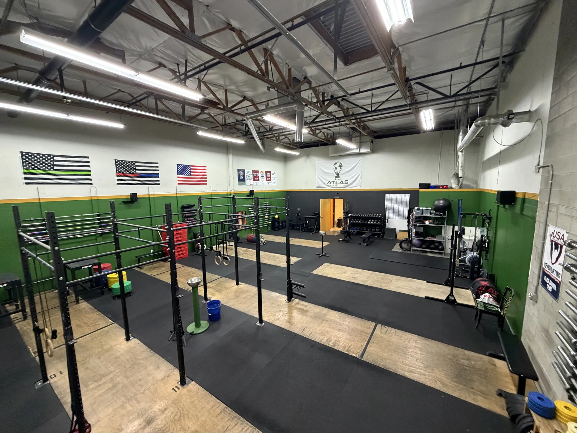 Atlas Barbell Club training floor with platforms, racks, and open space
